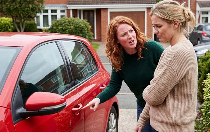 Two women arguing about a car scratch